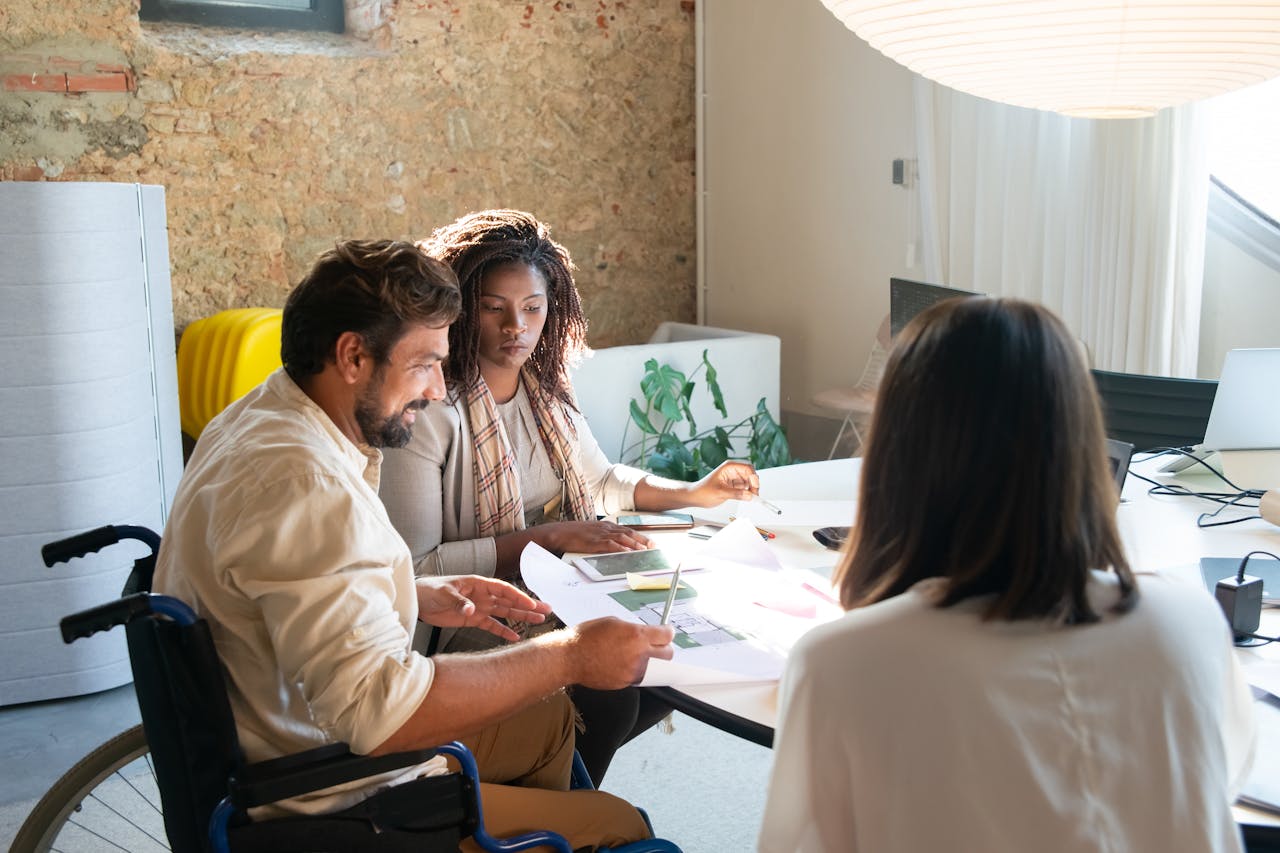 A diverse group of colleagues engaged in a productive meeting around a table in a bright office setting.